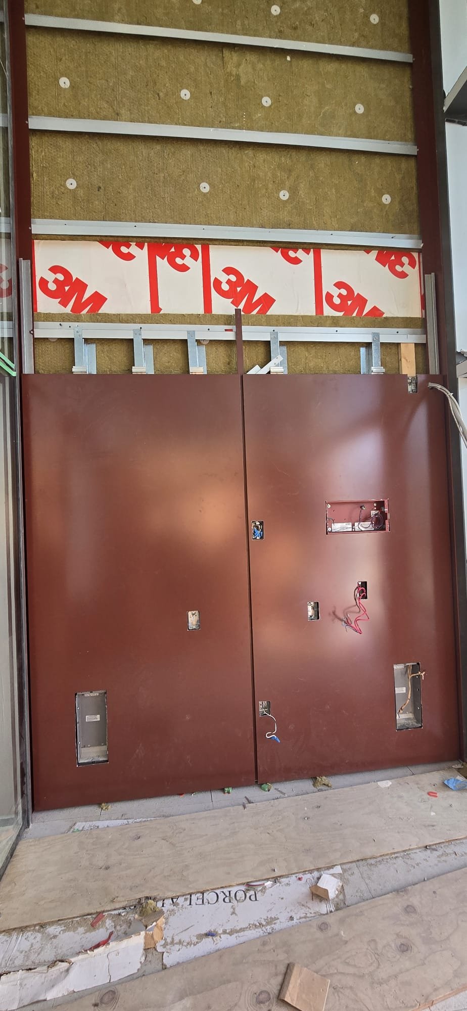 Level 2 mineral-wool insulation and red panel installation in progress
