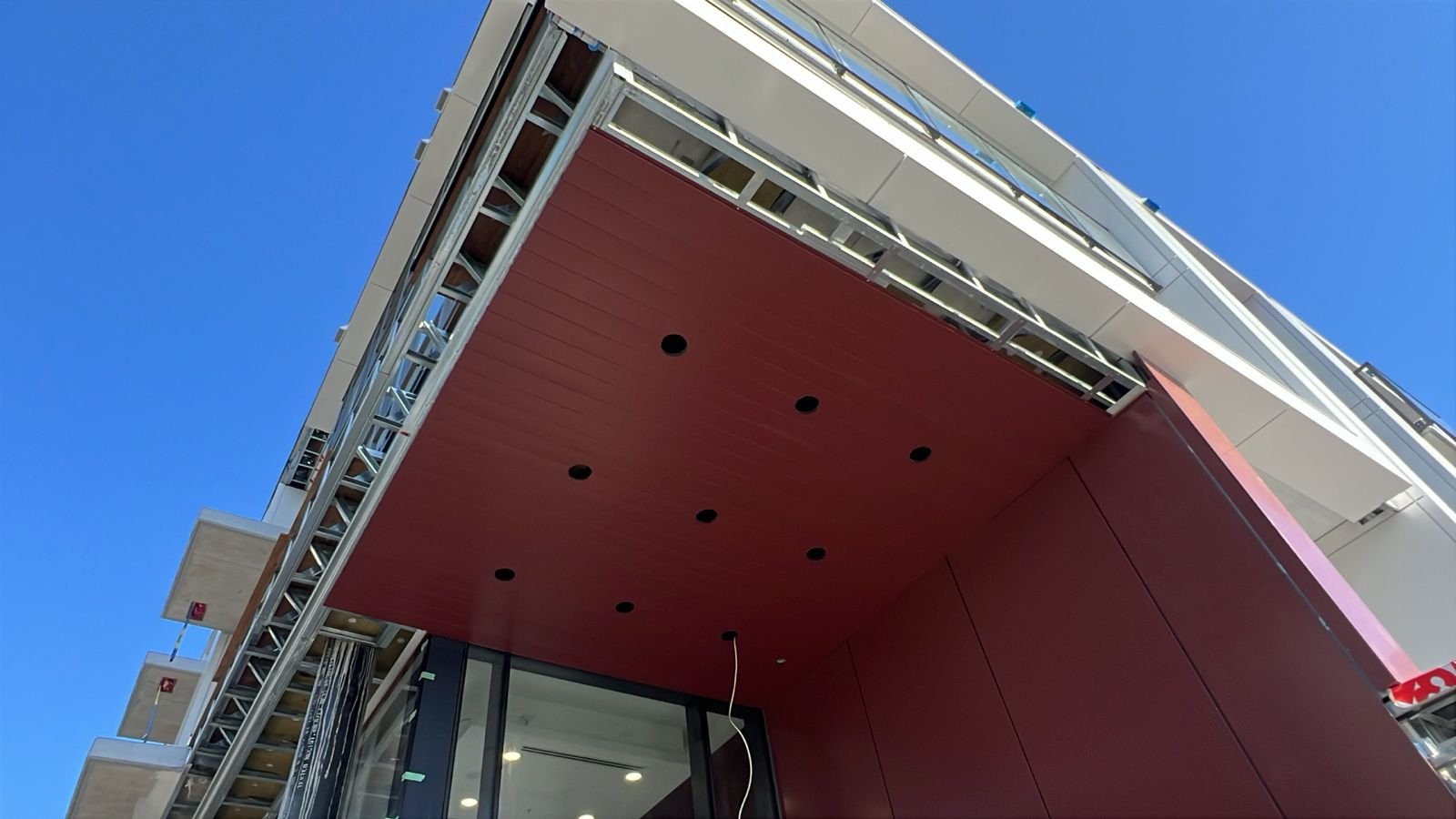 Custom-colour LUX soffit with integrated pot lights on the Oakmont entrance canopy